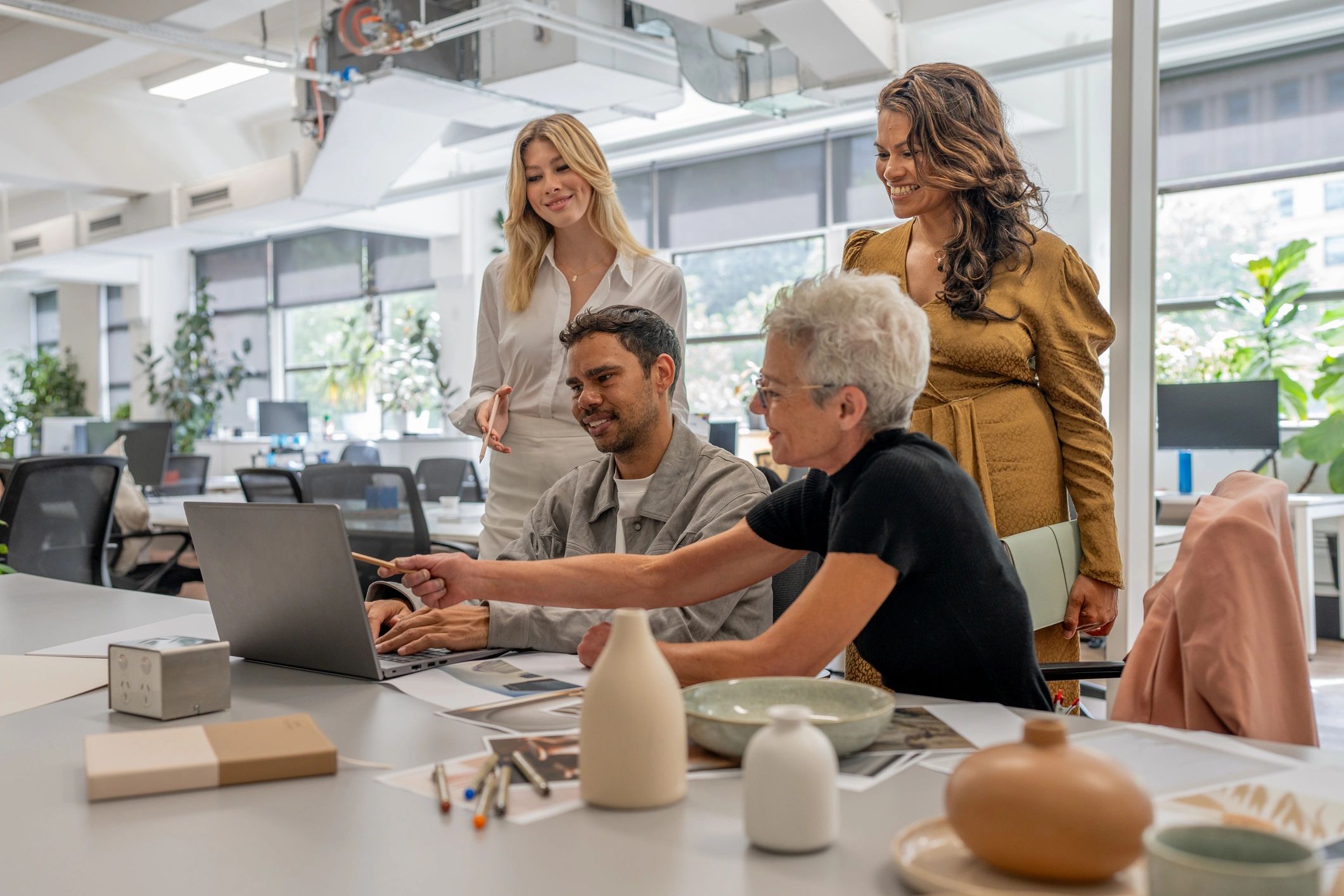 Cross-functional team collaborating around a laptop